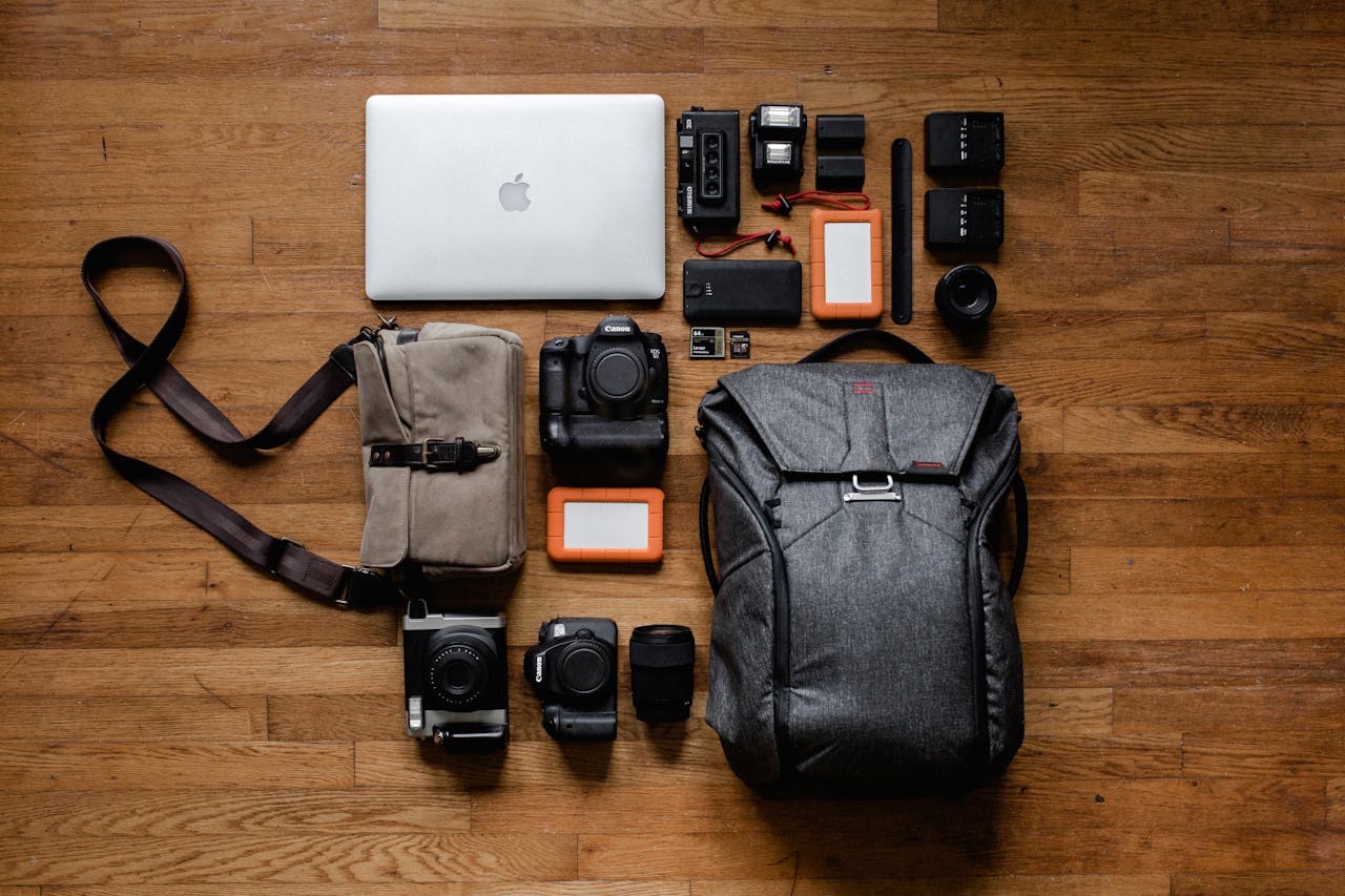 services-01 High-angle shot of camera equipment and laptop arranged on wooden floor for photography setup.